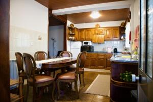 a kitchen with wooden cabinets and a table and chairs at Rosinha Country House in Vale de Cambra
