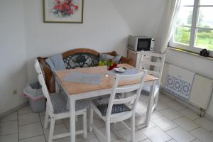 a dining room with a table and chairs and a kitchen at Ferienwohnung Rohwer in Jevenstedt