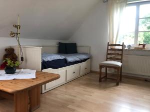 a bedroom with a bed and a table and a chair at Ferienwohnung Rohwer in Jevenstedt