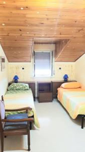 1 dormitorio con 2 camas y techo de madera en Tiziana, en Giardini Naxos