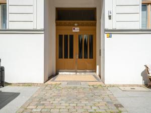 een houten deur in een wit gebouw met een stenen vloer bij Apartments Berlin Lottumstraße 4 in Berlijn