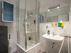 een badkamer met een glazen douche en een wastafel bij Apartments Berlin Lottumstraße 4 in Berlijn