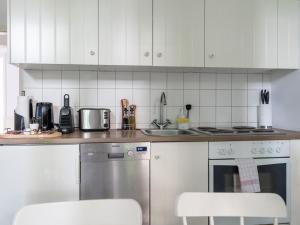 een keuken met witte apparaten en witte kasten bij Apartments Berlin Lottumstraße 4 in Berlijn +11 foto's