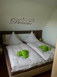 - une chambre avec 2 lits pourvus d'oreillers verts dans l'établissement Ferienwohnung "Bittner", à Thomsdorf