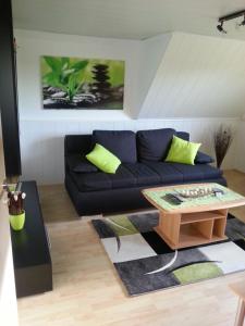 a living room with a black couch and a coffee table at Ferienwohnung "Bittner" in Altratjensdorf
