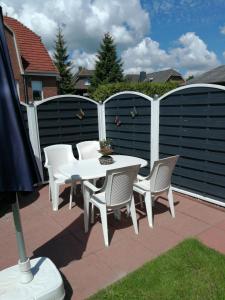 d'une terrasse avec une table, des chaises et une clôture. dans l'établissement Ferienwohnung "Bittner", à Thomsdorf