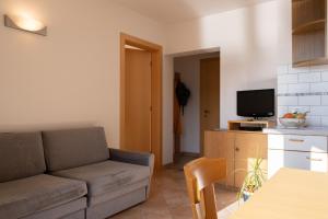 uma sala de estar com um sofá e uma televisão em Fewo Zweiraum im Haus Götsch 5 em Parcines