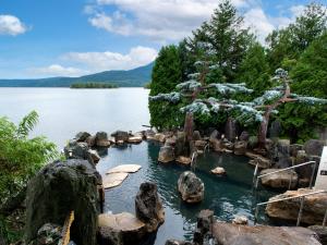 a pool of water with rocks in the middle of a lake at Akan Yuku no Sato Tsuruga in Akankohan