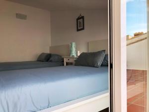 Schlafzimmer mit einem blauen Bett und einem Tisch in der Unterkunft AR27-5 Amplio ático en primera línea del casco antiguo in Villajoyosa