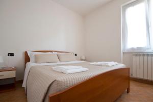 una camera da letto con un grande letto con due asciugamani di Ferienwohnung mit pool am Comer See a Domaso