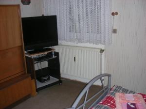 a room with a tv and a chair and a window at Ferienwohnung top Lage in Künzell