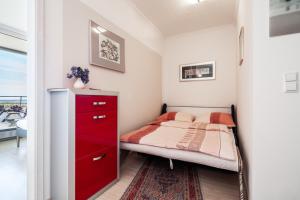 トラフェミュンデにあるFerienwohnung Alastor Travemündeの小さなベッドルーム(赤いドレッサー、ベッド付)