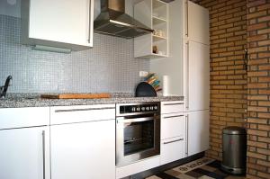 a kitchen with white appliances and a brick wall at Inselhaus OG in Staberdorf