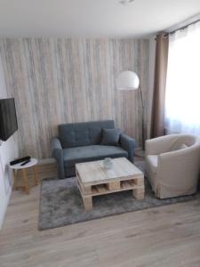 een woonkamer met een blauwe bank en een salontafel bij Meerchenhaus "Lagune" in Grömitz