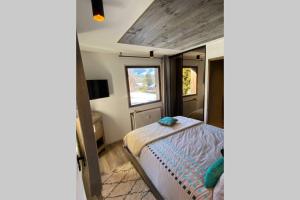 um pequeno quarto com uma cama e uma janela em Le FLOCON du Mont Darbois classé 3 étoiles em Megève