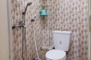 a bathroom with a toilet and a shower at Quattrick Dee Homestay Mitra RedDoorz in Manokwari +16 photos