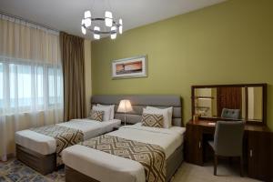 a hotel room with two beds and two lamps at Radiance Premium Suites in Dubai