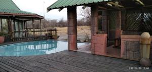 a house with a swimming pool on a wooden deck at Hanlin Lodge in Modimolle