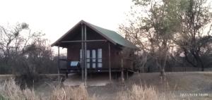a small house with a green roof in a field at Hanlin Lodge in Modimolle