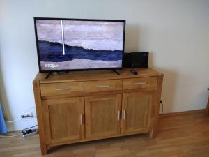 a flat screen tv sitting on top of a wooden cabinet at "Appartement 6 - Feriennest" - ab sofort mit W-LAN in Grömitz