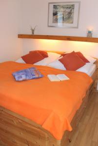 a large orange bed with two books on it at "Appartement 6 - Feriennest" - ab sofort mit W-LAN in Grömitz