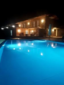a swimming pool in front of a house at night at B&b Il Poggio Eccelso in Ogliastro Cilento