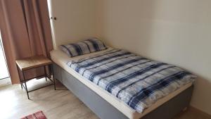 ein Bett mit einer karierten Decke und einem Stuhl in einem Zimmer in der Unterkunft Deichkrone App 11 in Grömitz