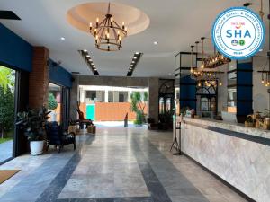 a lobby of a restaurant with a bar and a chandelier at Jomtien Longstay Hotel - SHA Plus Certified in Jomtien Beach +50 photos