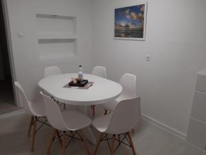 a white dining room with a white table and chairs at Ferienhaus Heide Zentrum in Heide