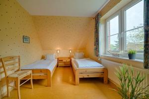 a small room with two beds and a window at "Ferienhof Seelust" Reihenhaus 9 in Gammendorf