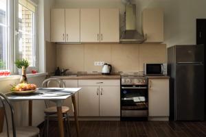 eine Küche mit einem Tisch und einem Kühlschrank aus Edelstahl in der Unterkunft 4 Apartment Between Two Lakes in Vilnius