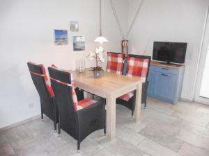 a dining room with a wooden table and chairs at Strandresidenz Deichgraf 2 Prerow in Zingst