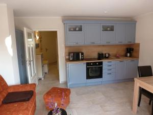a kitchen with blue cabinets and a stove top oven at Strandresidenz Deichgraf 2 Prerow in Zingst