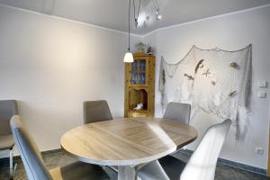 a dining room with a wooden table and chairs at Nele, Whg 3 in Zingst