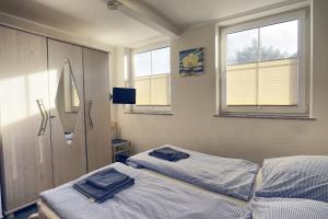 a bedroom with two beds and two windows at Nele, Whg 3 in Zingst
