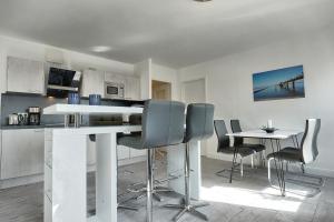 cocina con sillas y mesa en una habitación en Aparthotel "Am Kurhaus" 108, App Ostseeblick, en Zingst