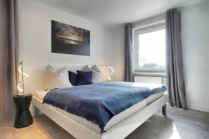 ツィングストにあるAparthotel "Am Kurhaus" 108, App Ostseeblickのベッドルーム1室(青い毛布付きのベッド1台付)