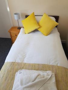 a bed with two pillows and a white comforter at The Station Hotel in Alness