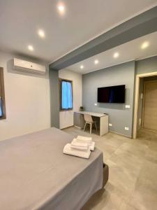 a bedroom with a bed with a desk and a tv at Floridida Rooms & Breakfast in Marina di Andora