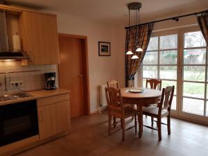 una cucina e una sala da pranzo con tavolo e sedie di Haus Weidenhof App 1 a Prerow