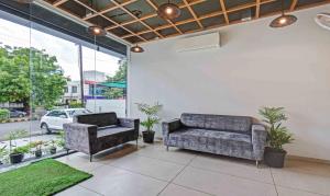 Treebo Trend Aroma Executive في أورانغاباد: غرفة معيشة مع كرسيين وأريكة