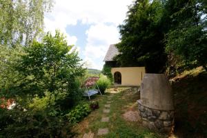 a garden with a stone path leading to a house at T&K 1 Vendégház Orfű in Orfű