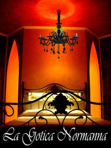 1 dormitorio con 1 cama con lámpara de araña en Casa Puccio B&B, en Caltabellotta