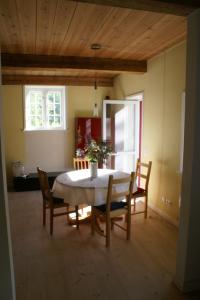 uma sala de jantar com uma mesa e cadeiras e duas janelas em Kate Windeby em Windeby