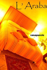 Una cama con sábanas de color naranja y almohadas. en Casa Puccio B&B, en Caltabellotta