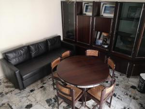 a living room with a table and a leather couch at Casa vacanze Sofia in Irsina