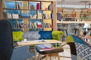 biblioteca con tavolo, sedie e librerie di Athens Starlight Hotel ad Atene
