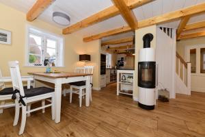 eine Küche und ein Esszimmer mit Kamin in einem Haus in der Unterkunft Uns witte Kaat in Oevenum