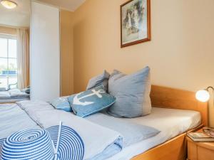 a bedroom with a bed with blue pillows on it at Strandstraße 51 Whg 1 in Zingst