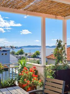 einen Balkon mit Blumen und Blick auf das Wasser in der Unterkunft Apartments Babin in Zadar
